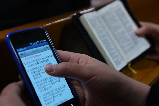 ▲한 교회에서 스마트폰으로 성경을 검색하는 성도와 성경책을 읽는 성도의 모습. ⓒ크리스천투데이 DB